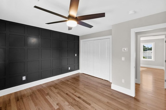 unfurnished bedroom featuring ceiling fan, light hardwood / wood-style floors, and a closet