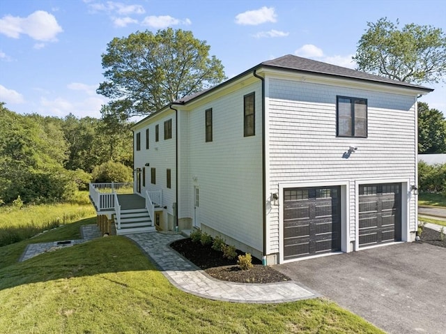 view of side of home with a garage and a lawn