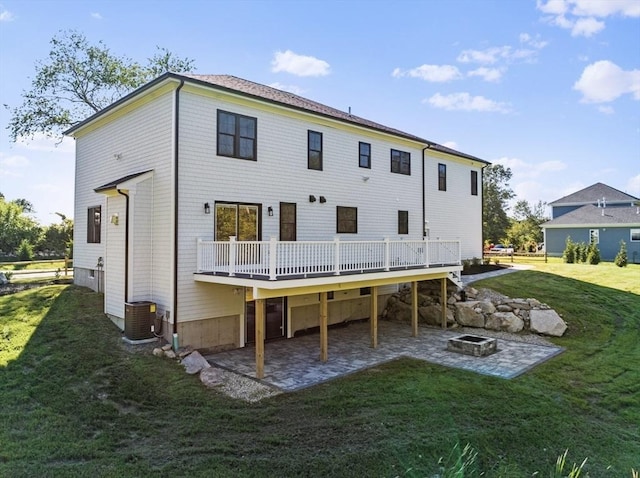 back of property with a fire pit, a patio area, central AC, and a deck