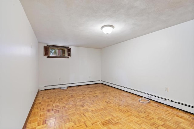 empty room featuring light parquet floors, a textured ceiling, and a baseboard radiator