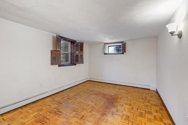 unfurnished room featuring baseboard heating and light parquet flooring