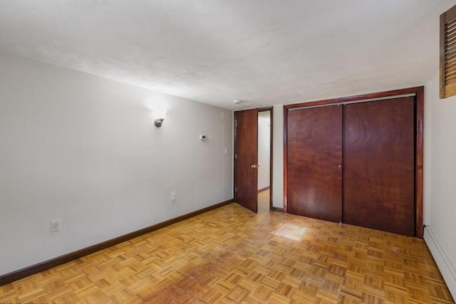 unfurnished bedroom with light parquet flooring and a closet