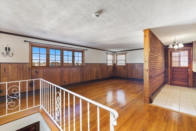 interior space featuring hardwood / wood-style flooring, ornamental molding, and an inviting chandelier