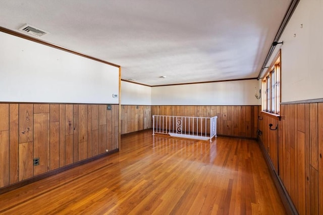 spare room with wood-type flooring and ornamental molding