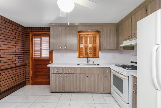 kitchen featuring baseboard heating, brick wall, white appliances, sink, and ceiling fan