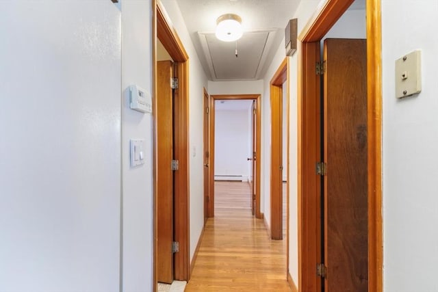 hallway with baseboard heating and light hardwood / wood-style floors