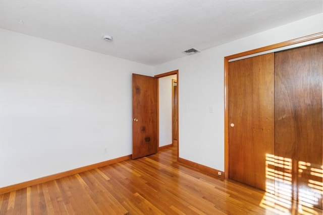 unfurnished bedroom featuring a closet and light hardwood / wood-style floors