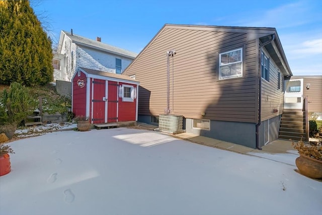 rear view of house featuring a shed, central AC unit, and a patio