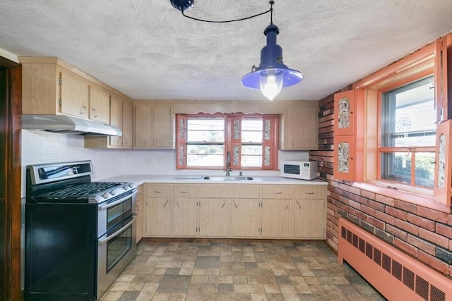 kitchen featuring double oven range, light brown cabinets, decorative light fixtures, radiator, and sink