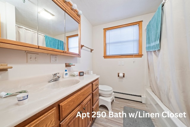 full bathroom with a baseboard radiator, hardwood / wood-style floors, toilet, shower / tub combo with curtain, and vanity