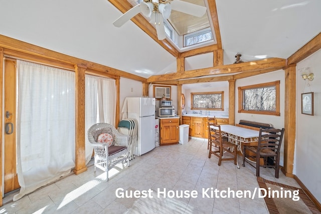 dining area with ceiling fan, high vaulted ceiling, and light tile patterned floors