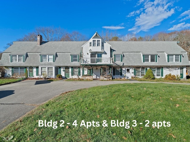 view of front of property featuring a wooden deck and a front yard