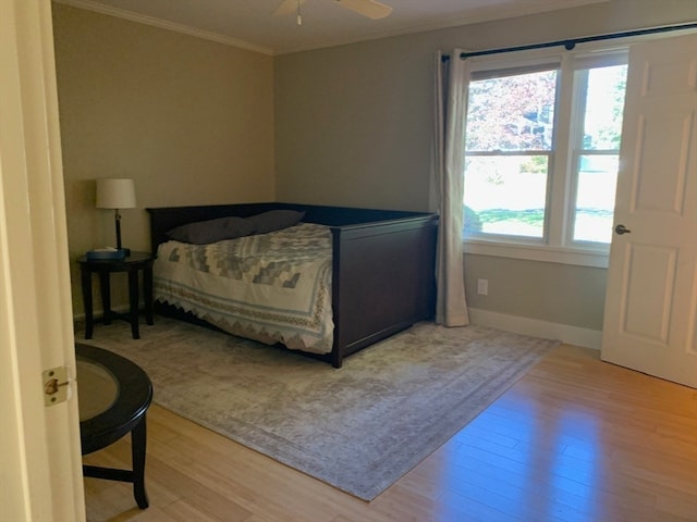 bedroom featuring ornamental molding, light wood-type flooring, and ceiling fan