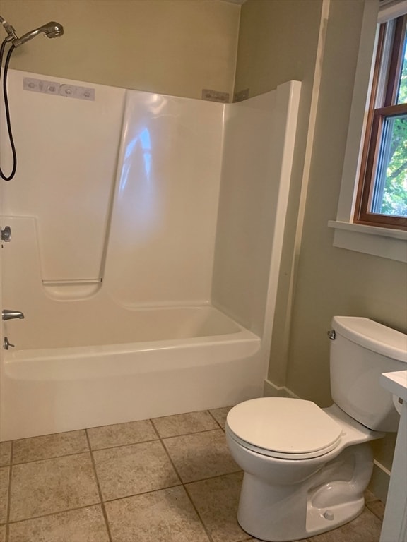 bathroom with toilet, tile patterned floors, and washtub / shower combination