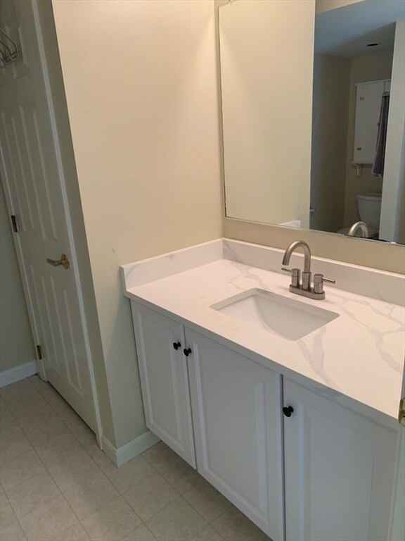 bathroom with vanity, toilet, and tile patterned floors