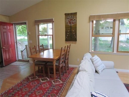 tiled dining room featuring vaulted ceiling