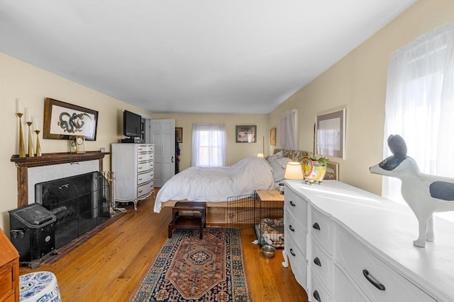 bedroom featuring a fireplace and light wood-style flooring