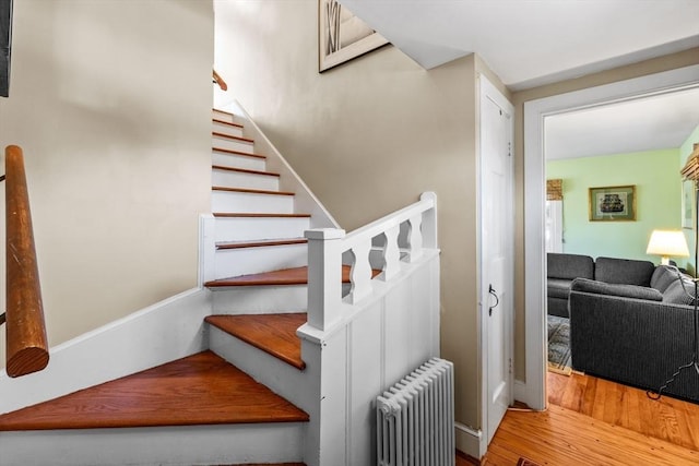 staircase with radiator heating unit and wood finished floors