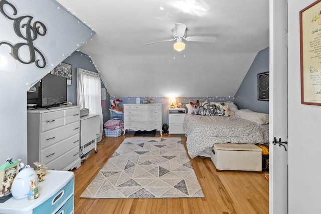 bedroom with lofted ceiling, light wood-style floors, and a ceiling fan