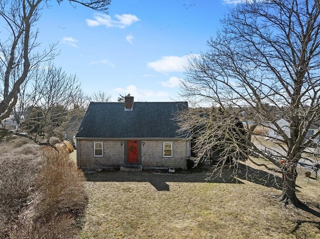 view of front facade featuring entry steps, a chimney, and roof with shingles