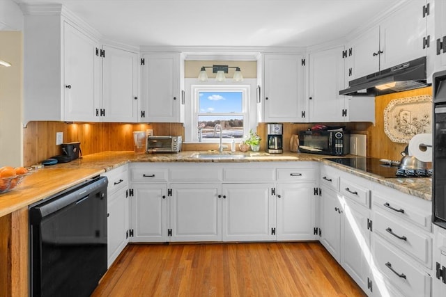 kitchen with white cabinets, light wood-style floors, under cabinet range hood, black appliances, and a sink