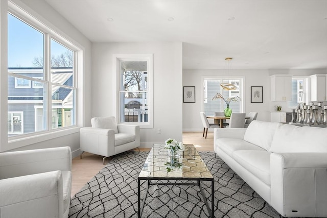living area featuring plenty of natural light, light wood finished floors, and baseboards