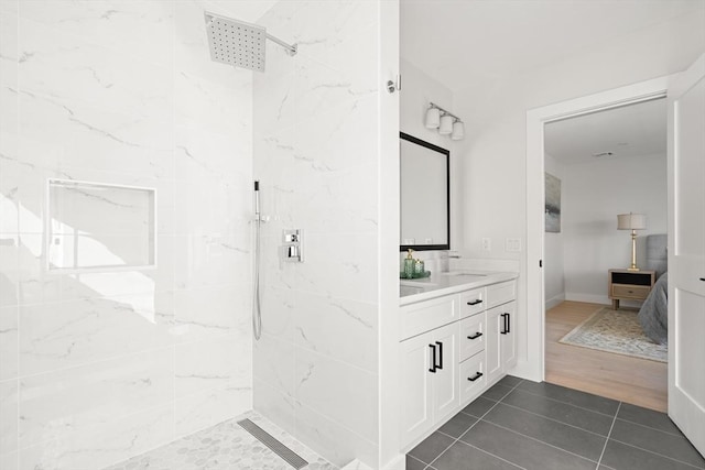 full bath featuring a marble finish shower, ensuite bath, vanity, and tile patterned floors