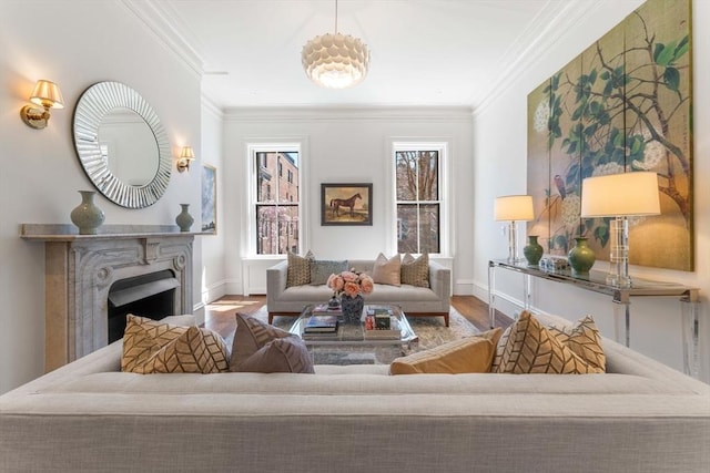 interior space featuring baseboards, wood finished floors, a fireplace, and crown molding