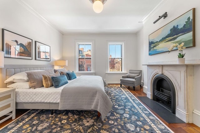 bedroom with crown molding, wood finished floors, a fireplace, and baseboards