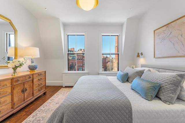 bedroom featuring baseboards, multiple windows, and dark wood-style flooring