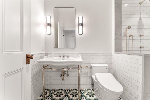 bathroom with tile patterned floors, wainscoting, tile walls, and toilet