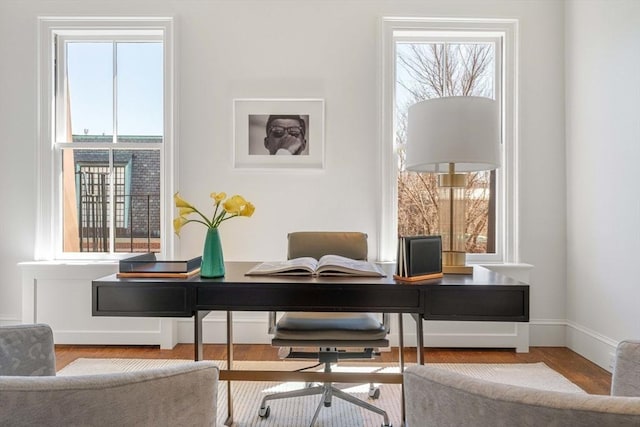 home office with baseboards and wood finished floors