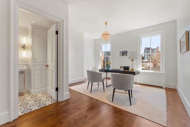 dining space with baseboards and wood finished floors