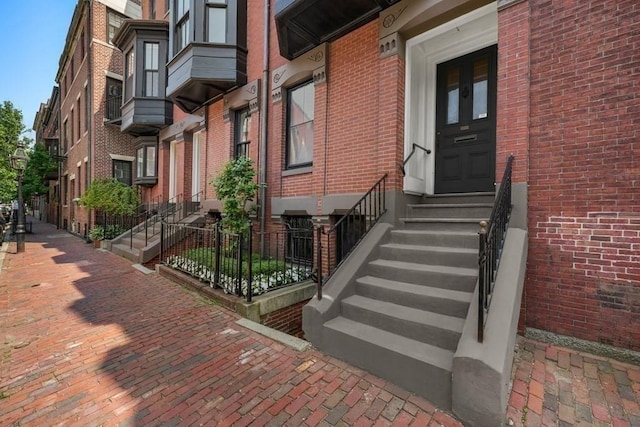 doorway to property featuring brick siding