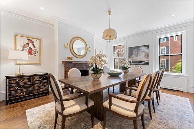 dining space with recessed lighting, wood finished floors, and crown molding