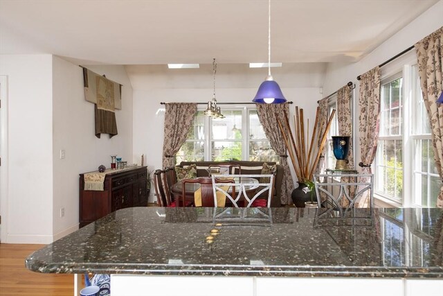 2181 Service Rd, Barnstable, MA 02668 - kitchen with wood finished floors, hanging light fixtures, dark stone counters, and baseboards