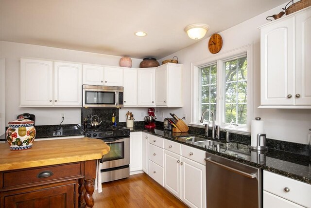 2181 Service Rd, Barnstable, MA 02668 - kitchen with stainless steel appliances, a sink, dark stone countertops, white cabinetry, and recessed lighting