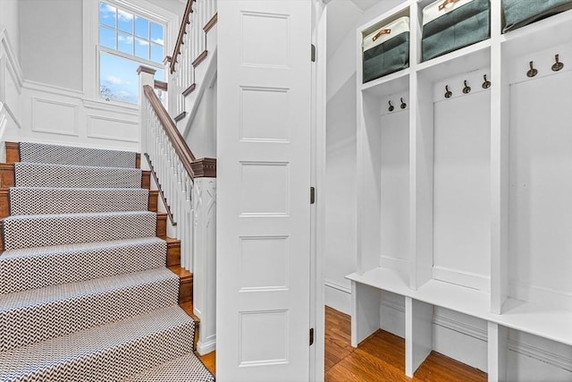 mudroom featuring light wood finished floors and a decorative wall