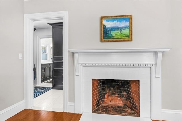 interior details with a fireplace, baseboards, and wood finished floors