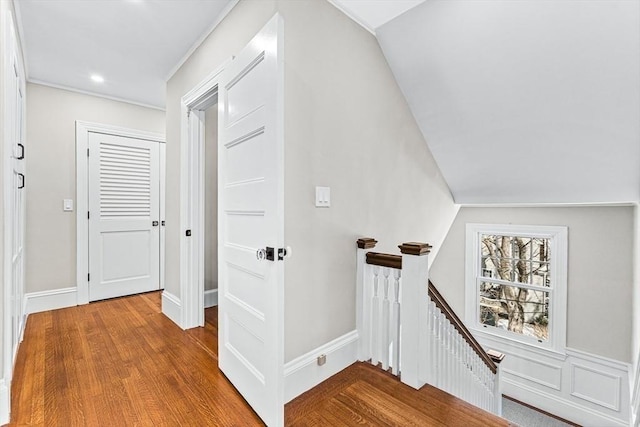 corridor featuring recessed lighting, wood finished floors, and an upstairs landing