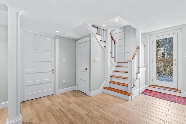 foyer with light wood-style flooring, stairs, baseboards, and recessed lighting