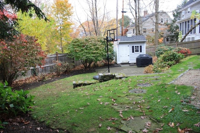 view of yard with a patio area, a fenced backyard, and an outdoor structure