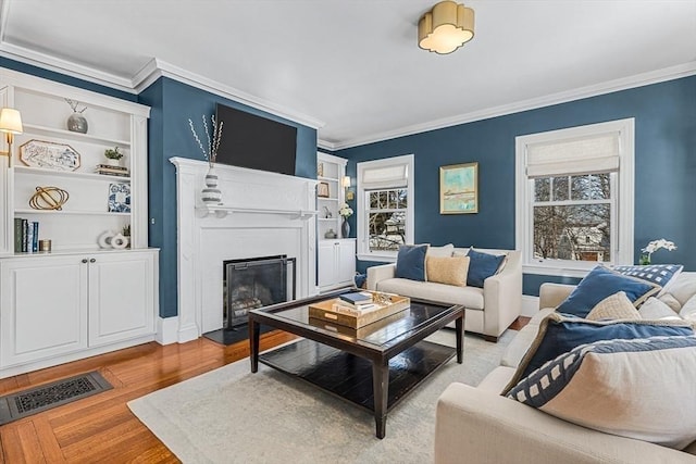 living area featuring ornamental molding, a wealth of natural light, visible vents, and a fireplace