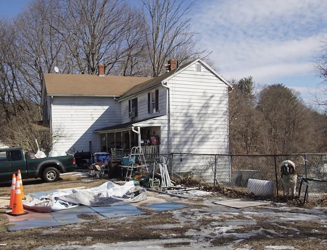 view of property exterior with a sunroom and fence