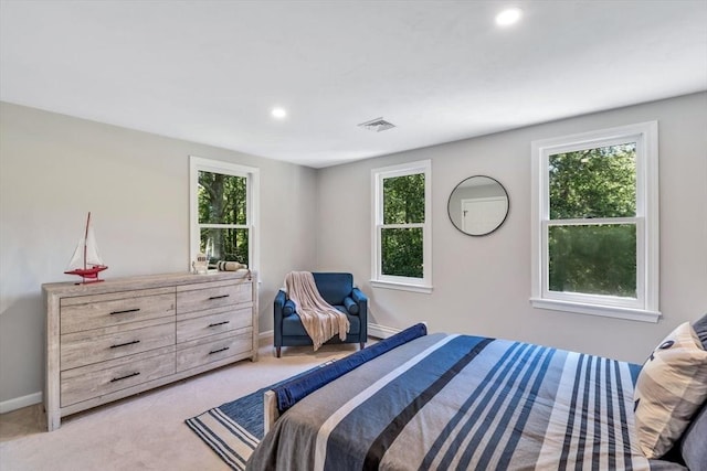 bedroom featuring multiple windows and light colored carpet