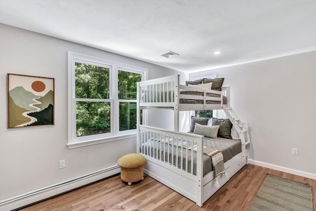 bedroom with a baseboard radiator and wood-type flooring