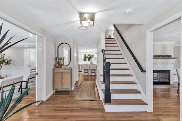 foyer entrance featuring a brick fireplace and hardwood / wood-style flooring