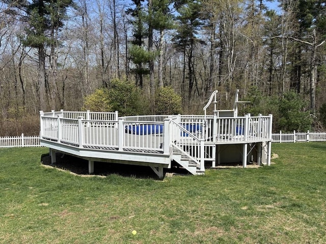 wooden terrace featuring a yard and fence