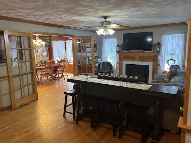 living room with ornamental molding, light wood-style flooring, and a wealth of natural light