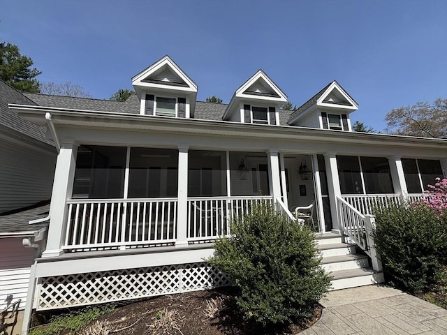 farmhouse inspired home with a shingled roof and a sunroom